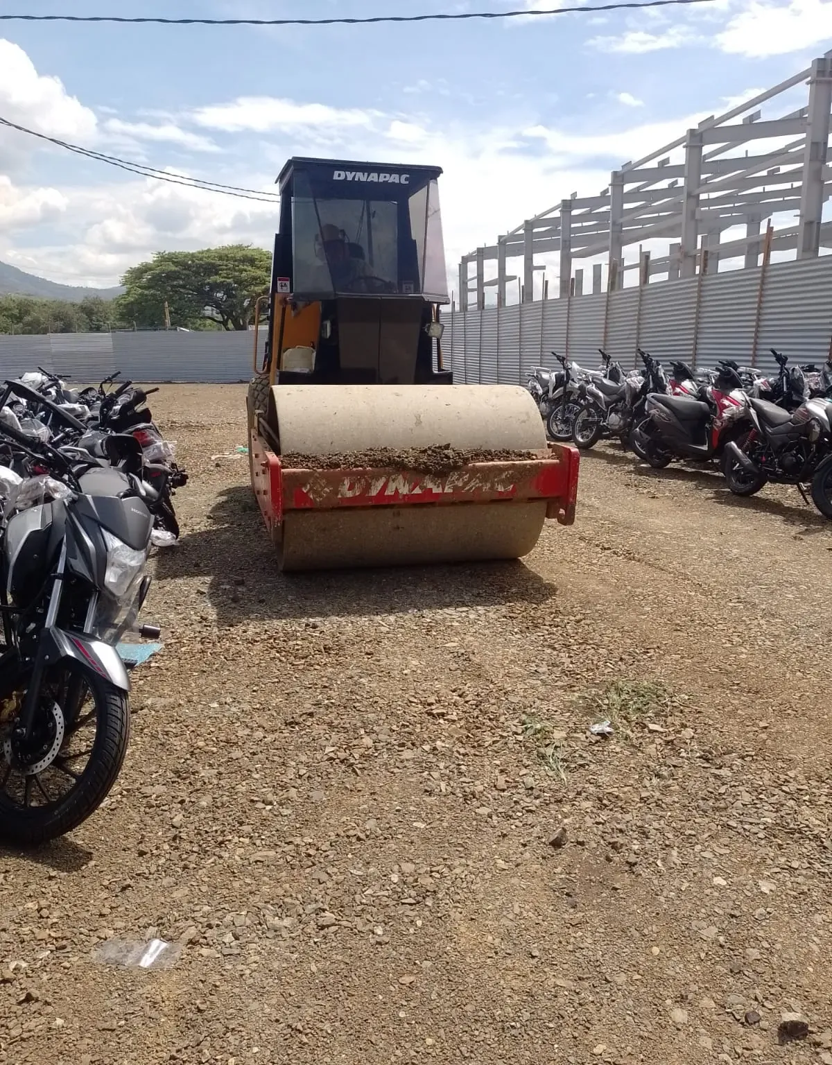 Cilindro compactador sobre la base granular de una vía interna terminada.
