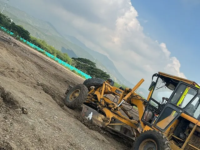 Motoniveladora en un frente de obra, contraluz de cielo abierto.